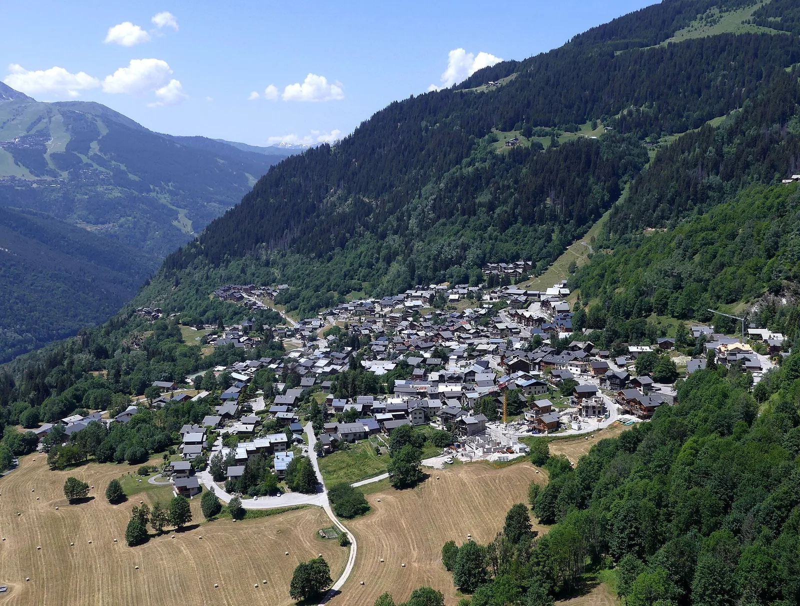 Toits et chalets de Champagny-en-Vanoise en début d'été, montagnes au loin